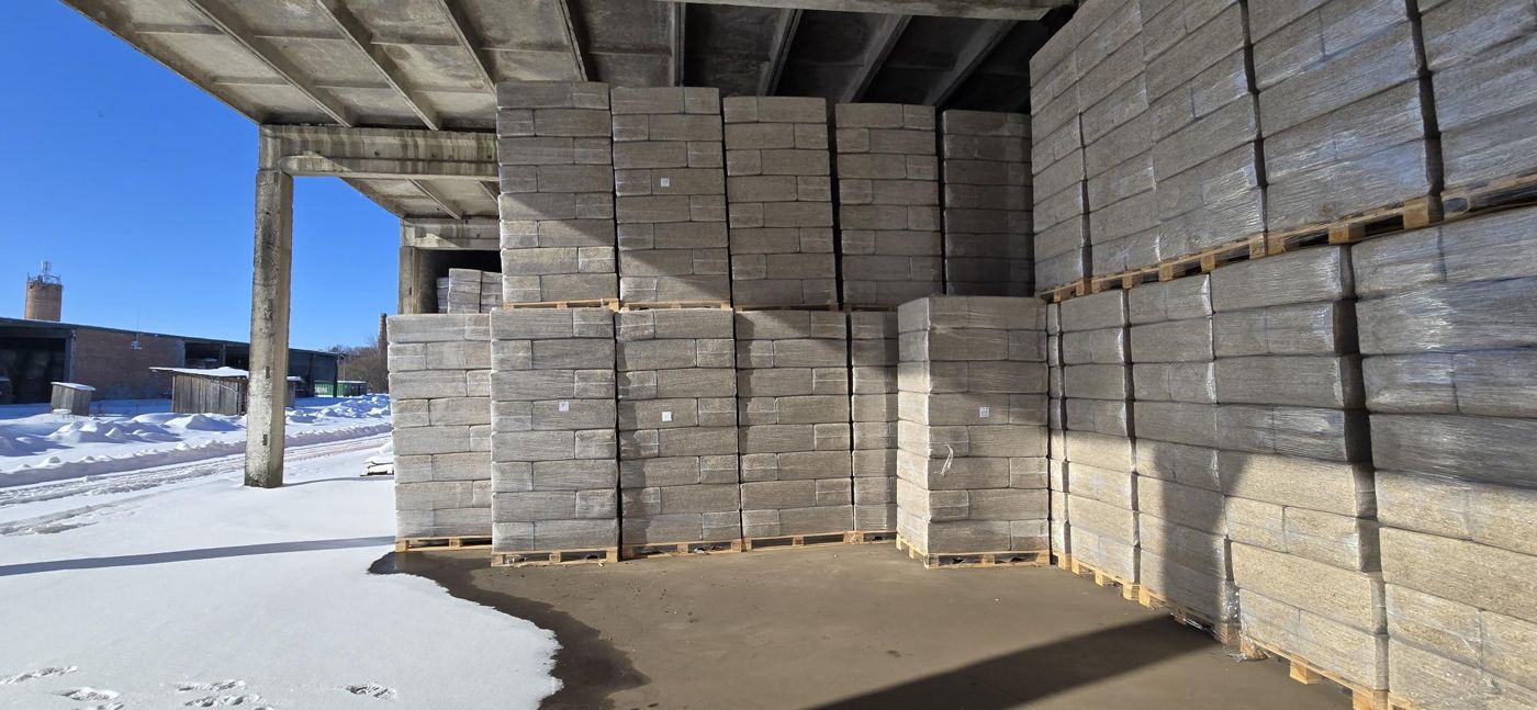 Pallets of hemp bedding bales in a warehouse
